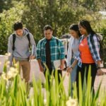 A diverse group of college students walking outdoors, enjoying each other's company and smiling.