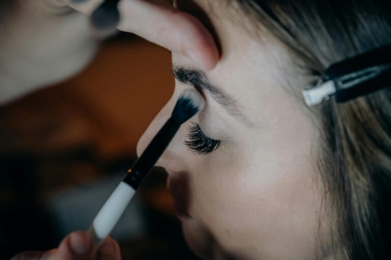A detailed shot of a woman getting eye makeup applied with precision and artistry.
